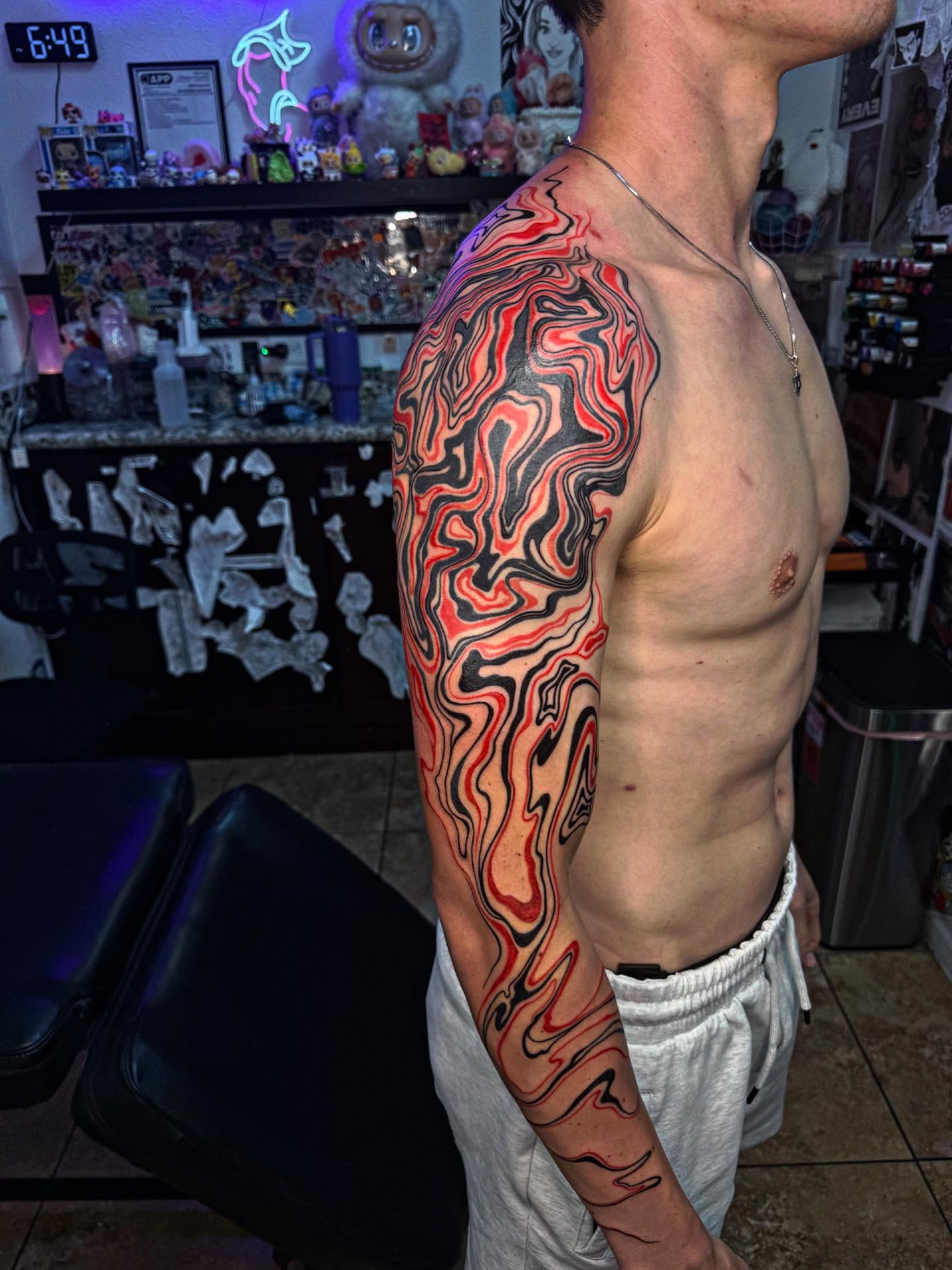 Abstract flame new school tattoo on the upper arm by McKenna Hughes