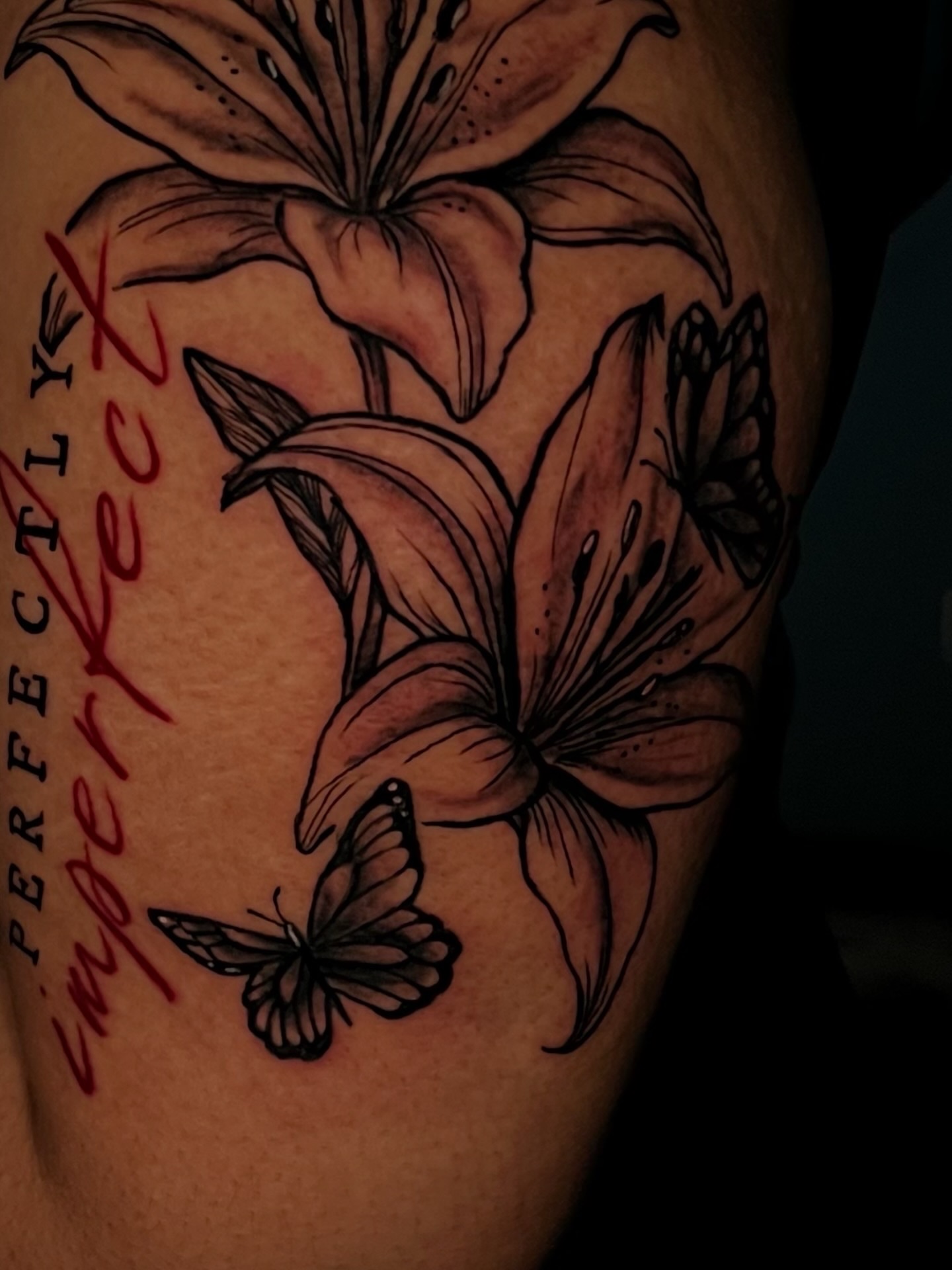 Lilies and butterflies black and grey tattoo on the upper arm by Unknwn Ink ⭐️