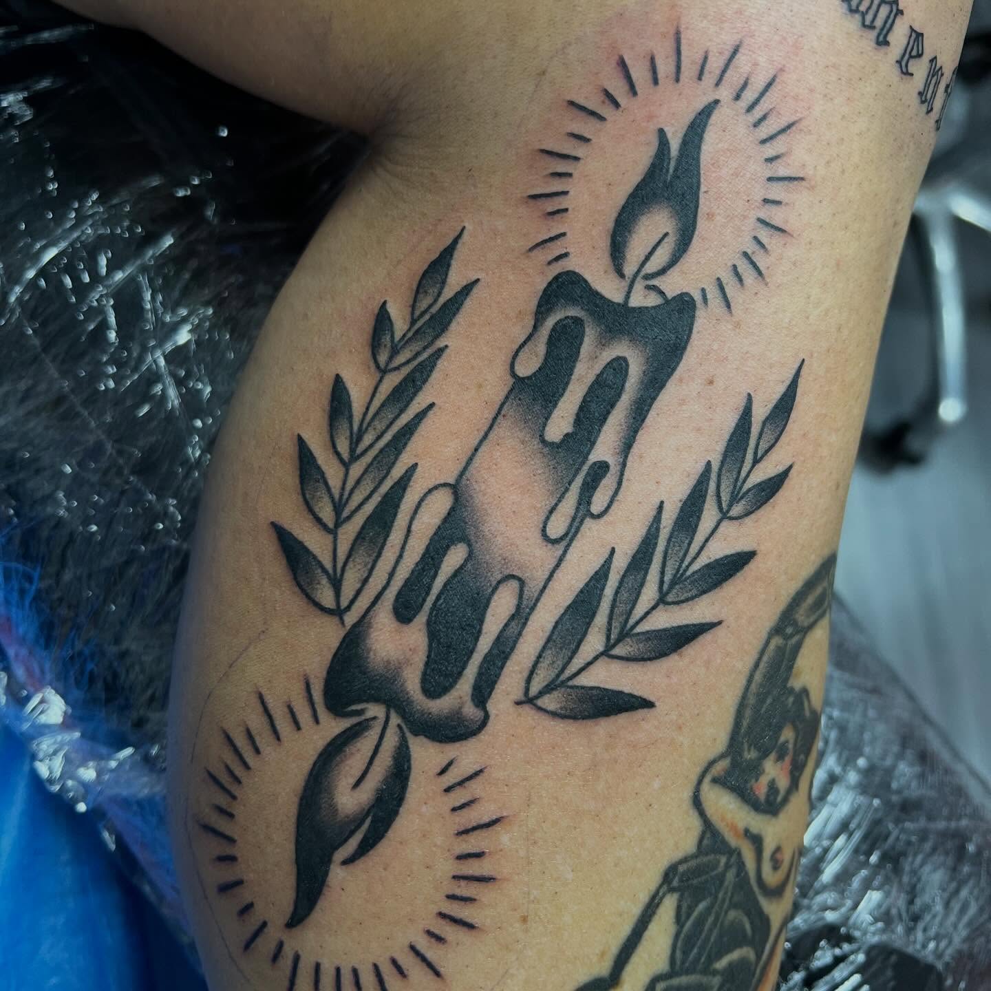 Candle and laurel wreath American traditional tattoo on the thigh by Ben Riffe