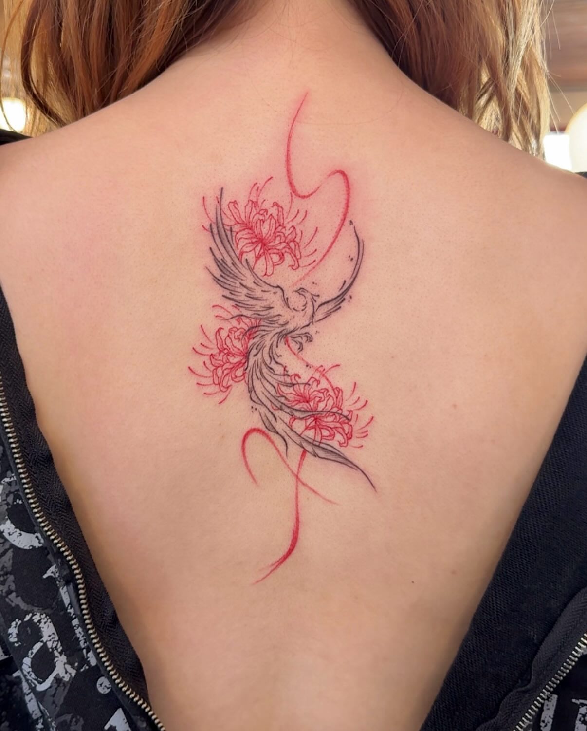 Phoenix and flowers neo-traditional tattoo on the back by Ethan