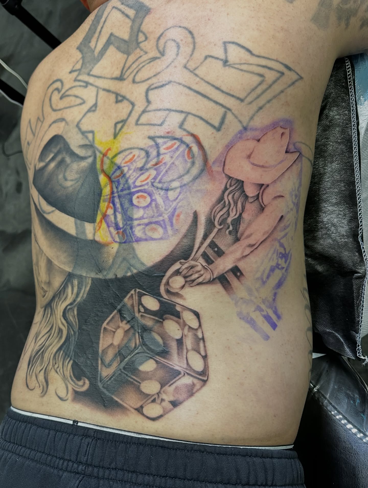 Dice and woman black and grey tattoo on the ribs by Dani B.