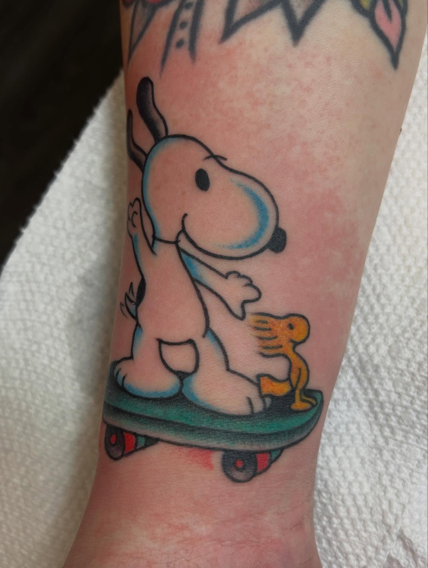 Snoopy on skateboard new school tattoo on the forearm by Kelsey Lyons