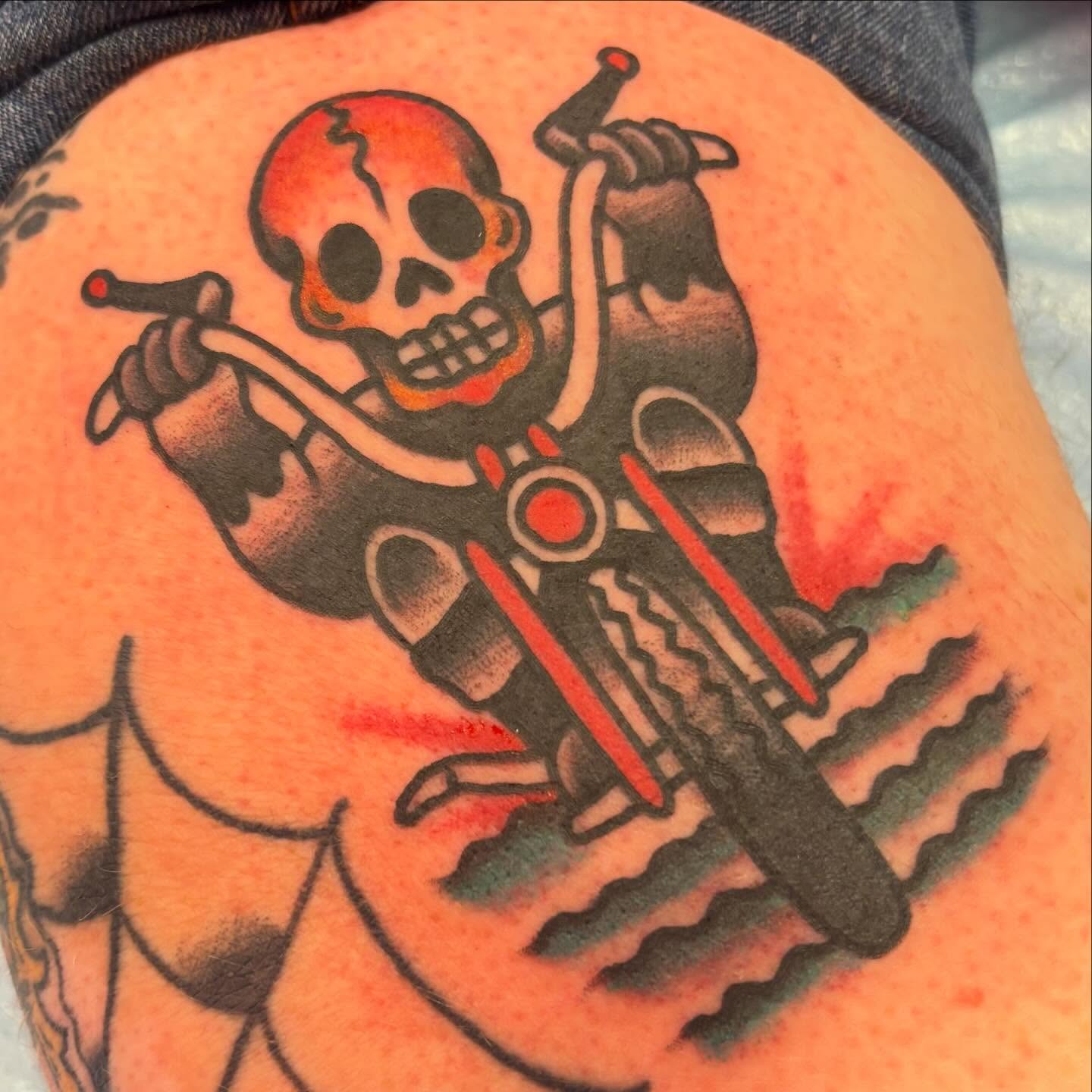 Motorcycle rider skeleton American traditional tattoo on the shoulder by @dannydoestattoos