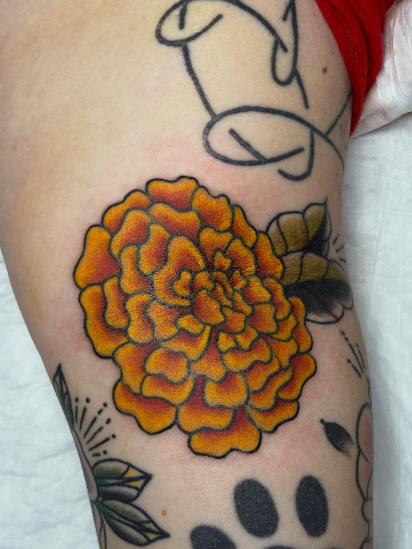 Marigold flower American traditional tattoo on the forearm by gia❤️‍🔥🎲, Maryville, Tennessee