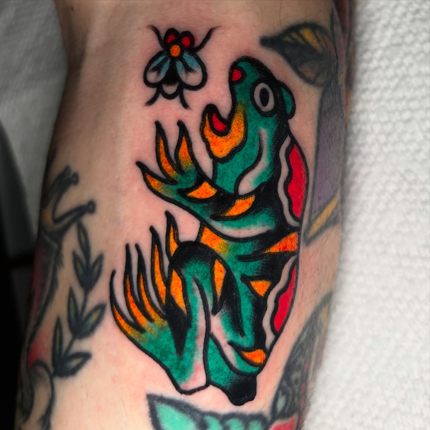 Parrot and flower American traditional tattoo on the forearm by Santo Zelaya, San Francisco, California