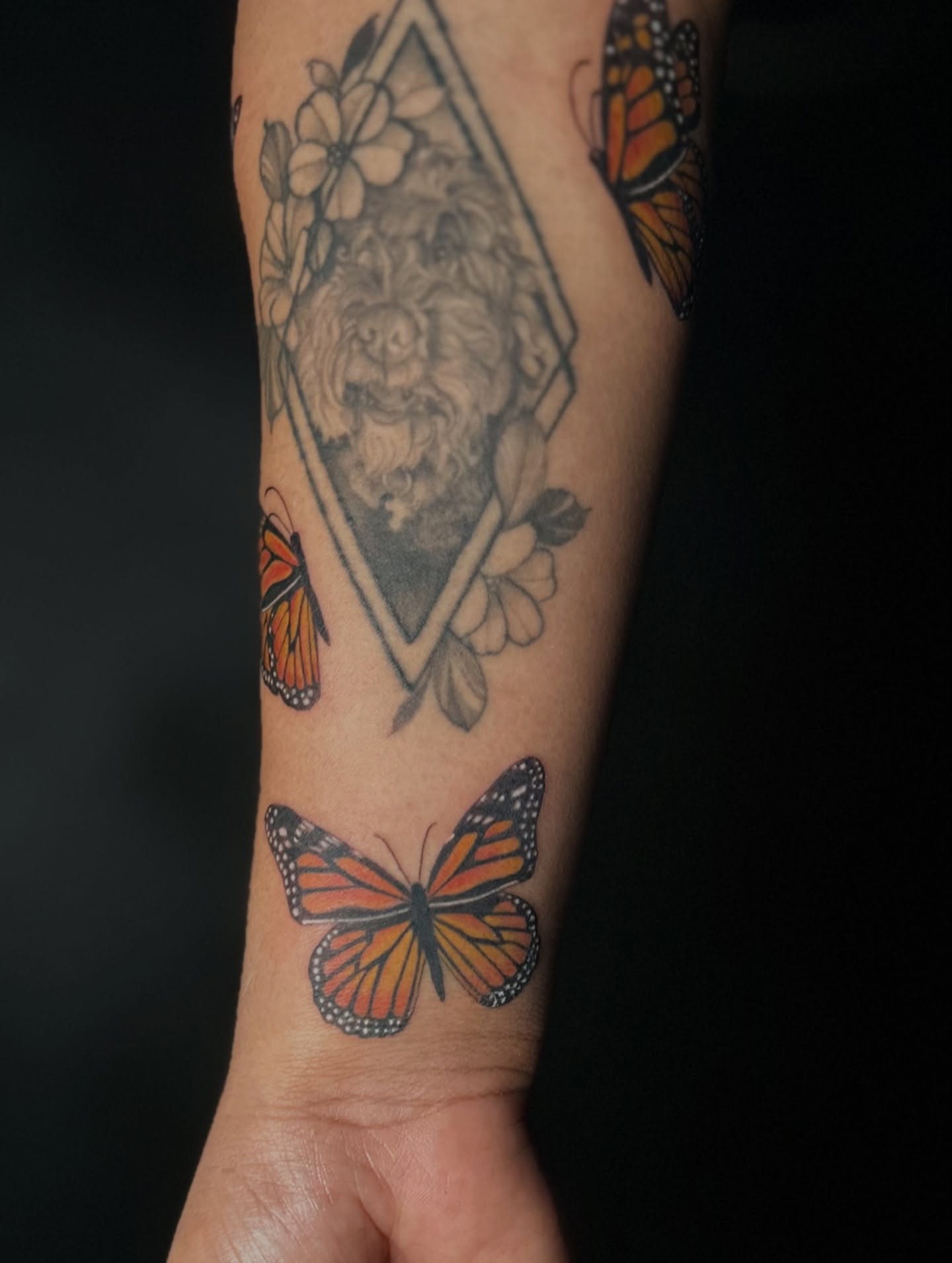 Monarch butterflies and lion geometric tattoo on the forearm by Vicious Marc