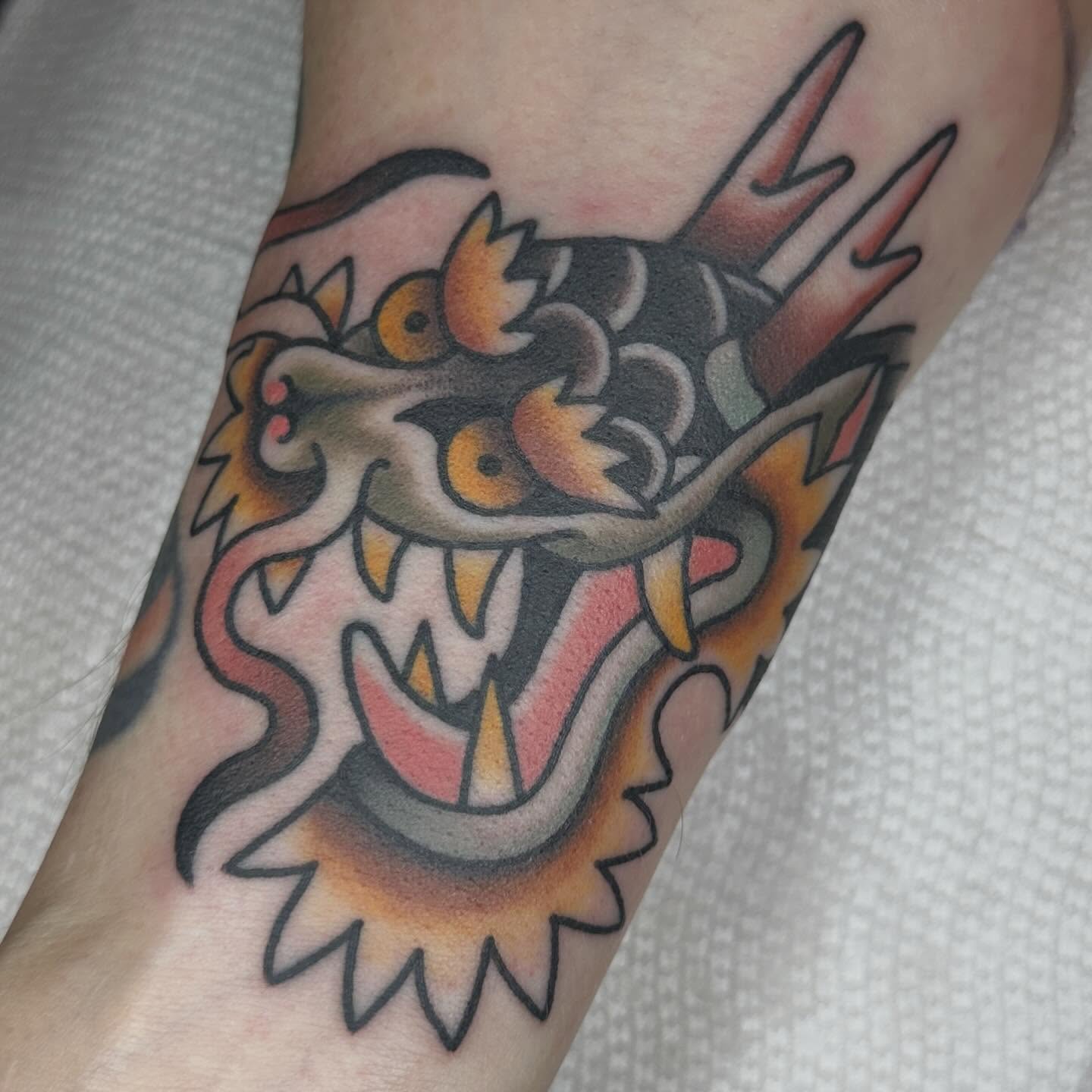Dragon head American traditional tattoo on the forearm by Kyle Logan Frary