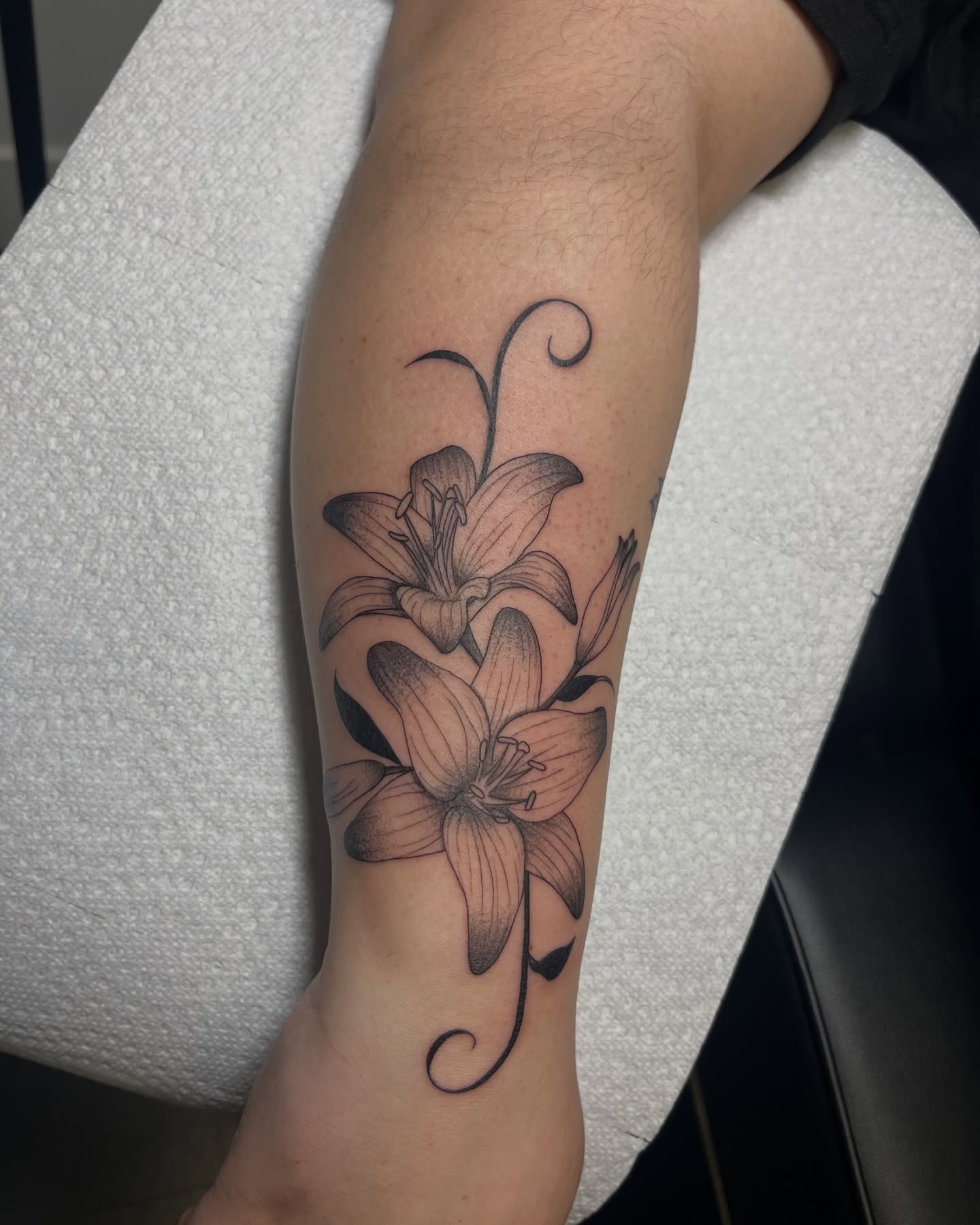 Lily black and grey tattoo on the forearm by Daniela