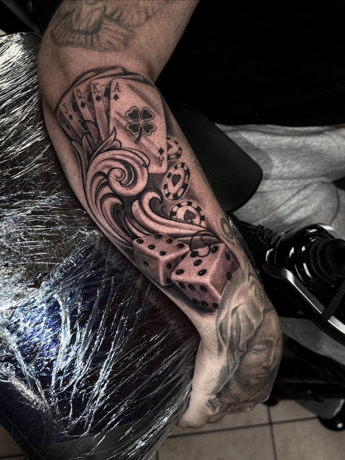Playing cards and dice black and grey tattoo on the forearm by Stilow Memphis Tattoo Artist, Memphis, Tennessee