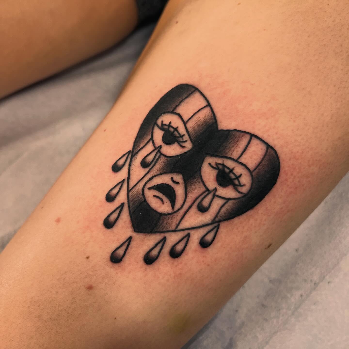 Heart with eyes and mouth black and grey tattoo on the forearm by Samantha Citer