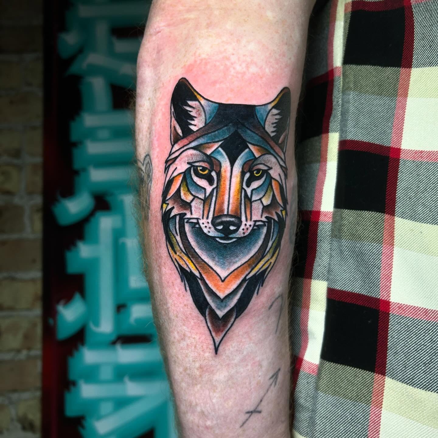Wolf head geometric tattoo on the forearm by Alycia