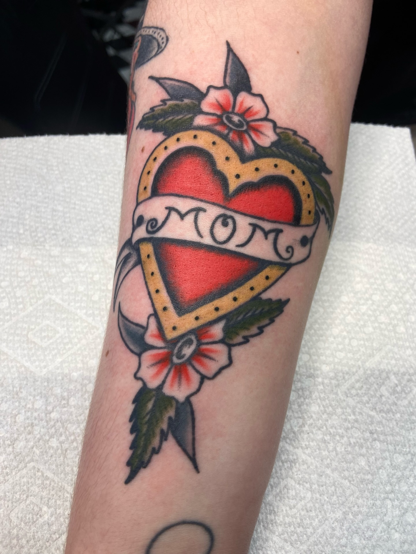 Heart with 'mom' banner American traditional tattoo on the forearm by R y a n S m i t h