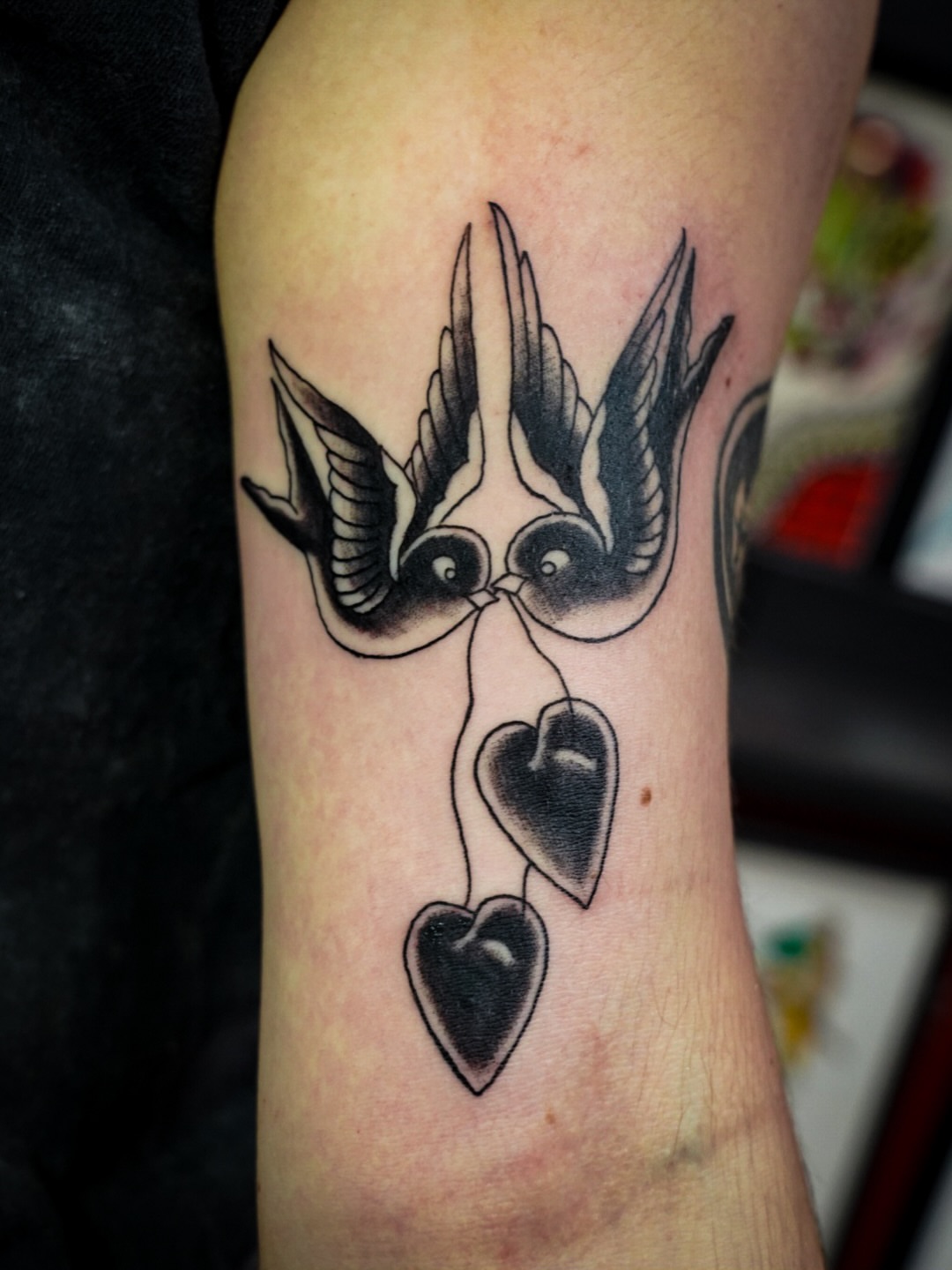 Swallows and hearts black and grey tattoo on the forearm by Spicoli