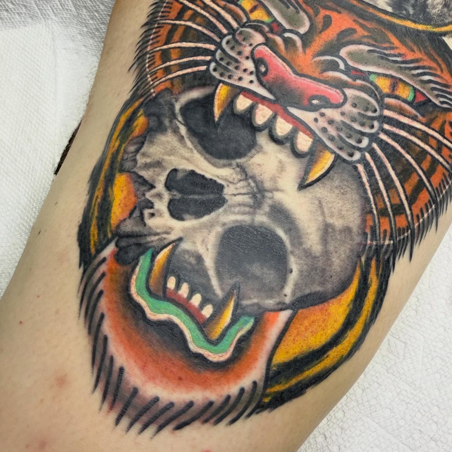 Skull with feathers American traditional tattoo on the thigh by Ryan
