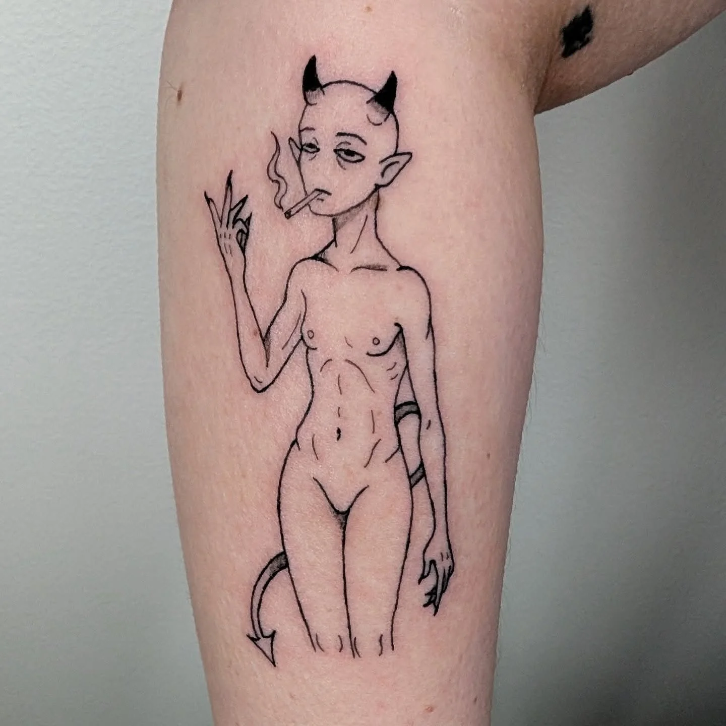 Naked devil smoking minimalist tattoo on the forearm by Karis Yoo▪️Licensed Tattoo Artist