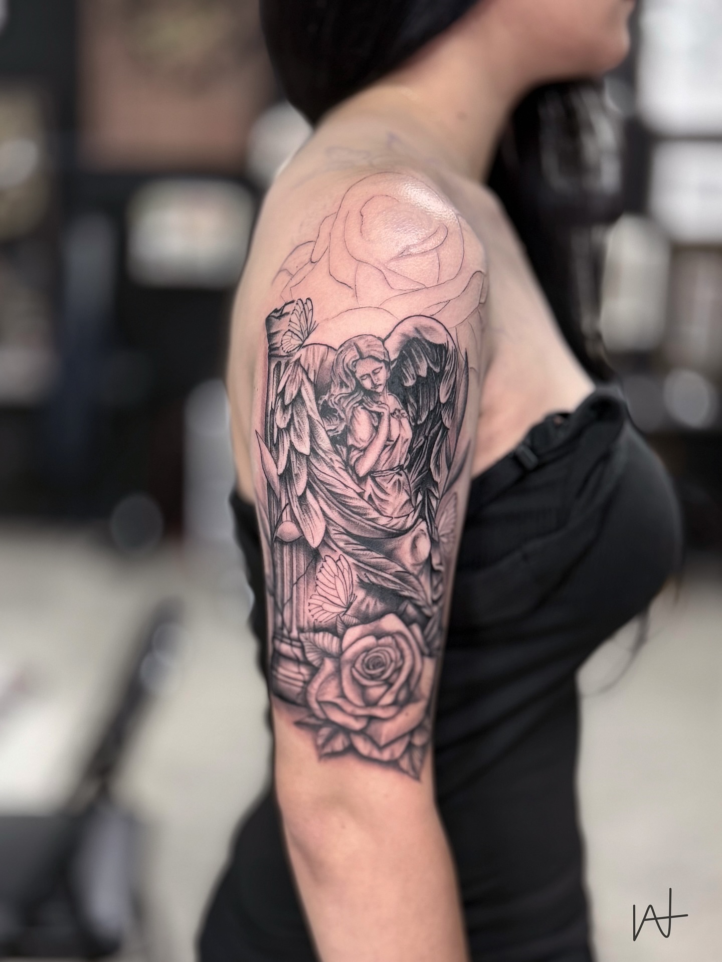 Angel and roses realism tattoo on the upper arm by Kat Parmu