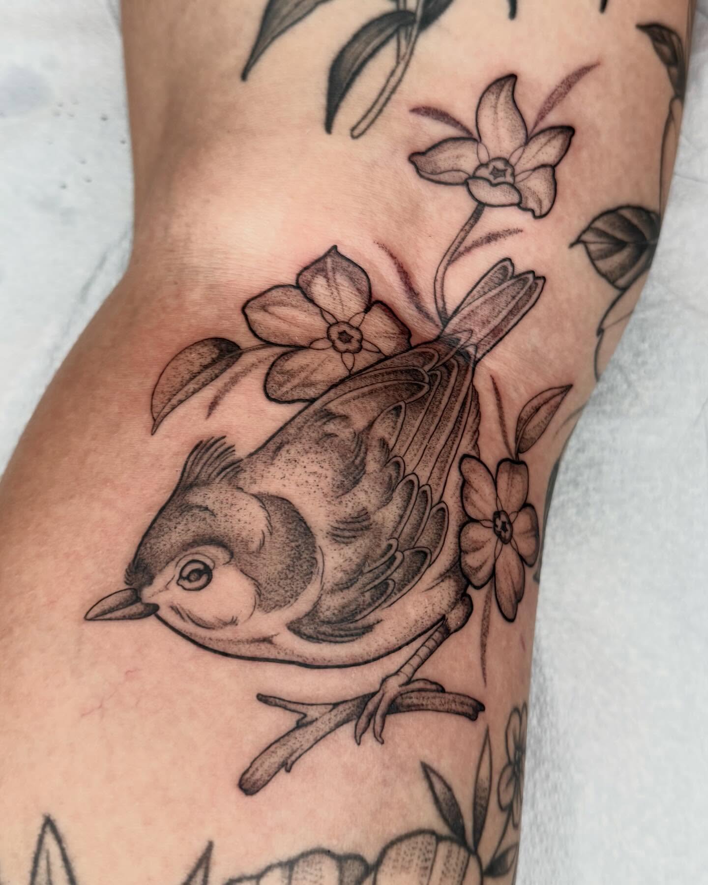 Bird and flowers black and grey tattoo on the forearm by 🌸delaney🌸