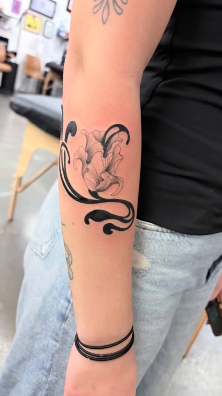 Floral design with swirling accents fine line tattoo on the forearm by Kenzie Mecham-Cunningham