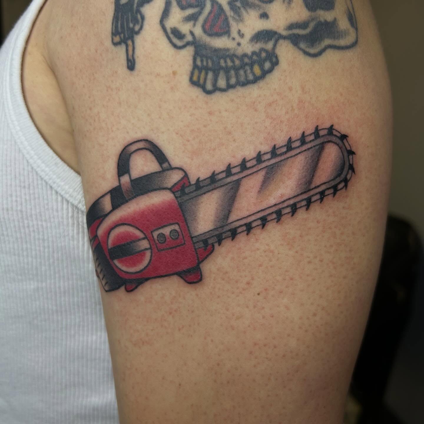 Chainsaw American traditional tattoo on the upper arm by Bregan ✨