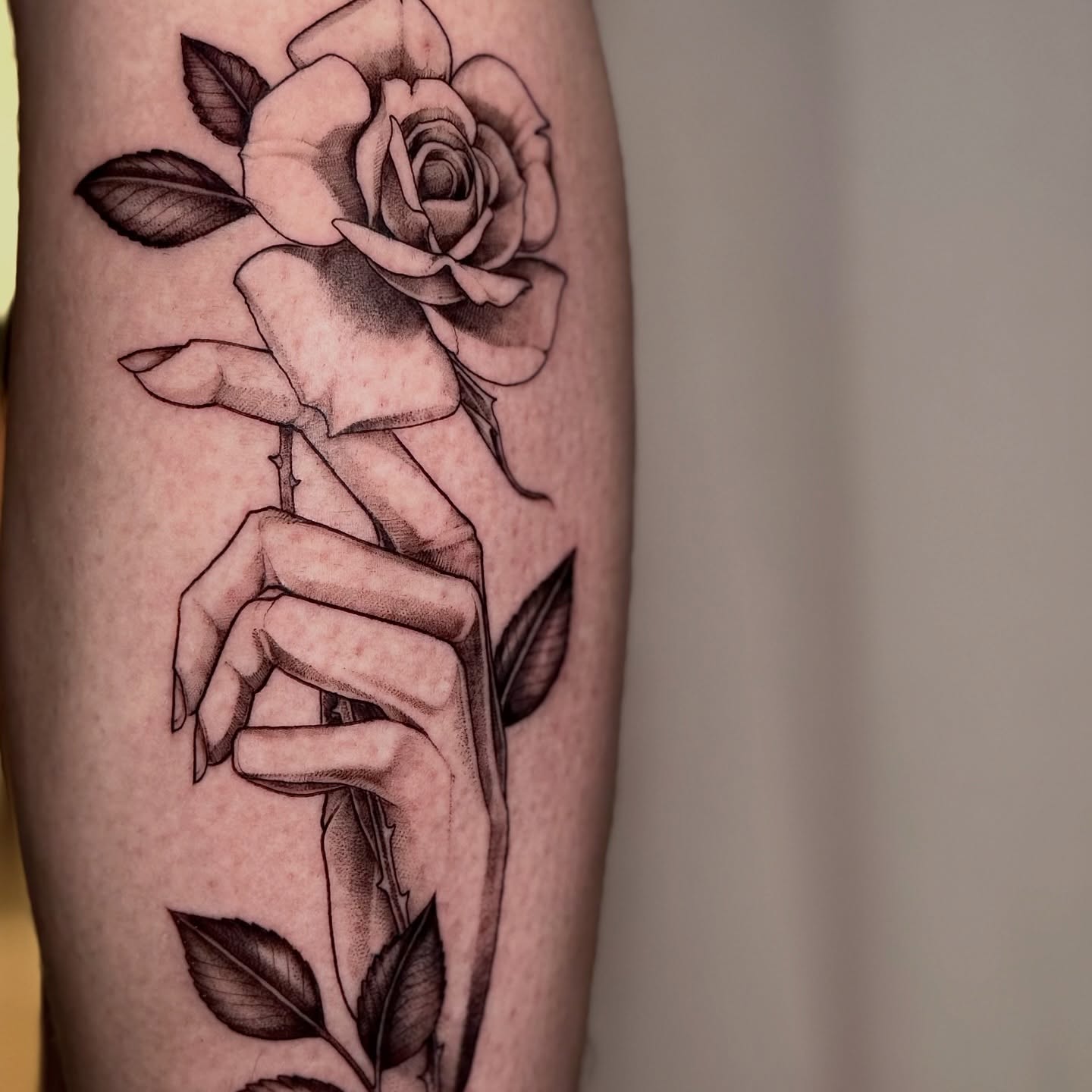 Rose and hand black and grey tattoo on the forearm by Lydia Jude