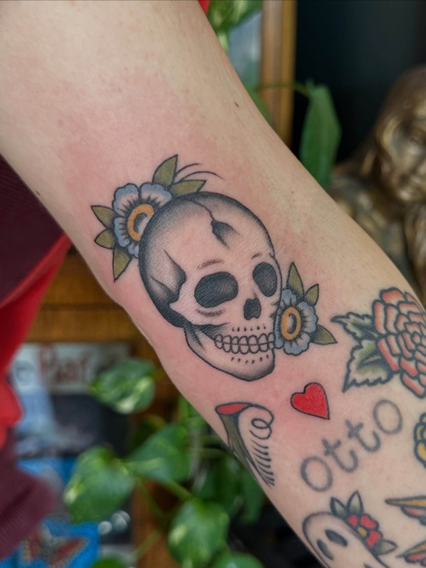 Skull with flowers American traditional tattoo on the forearm by Max Peterson