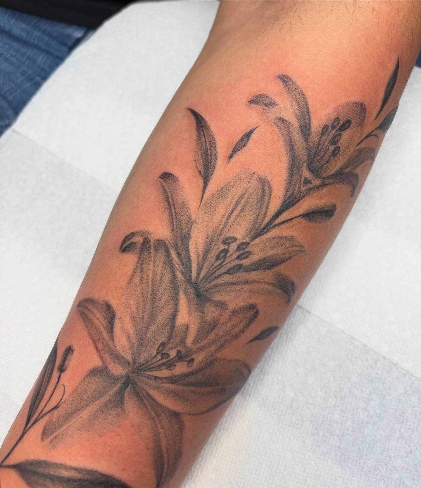 Lilies black and grey tattoo on the forearm by Jackie π€