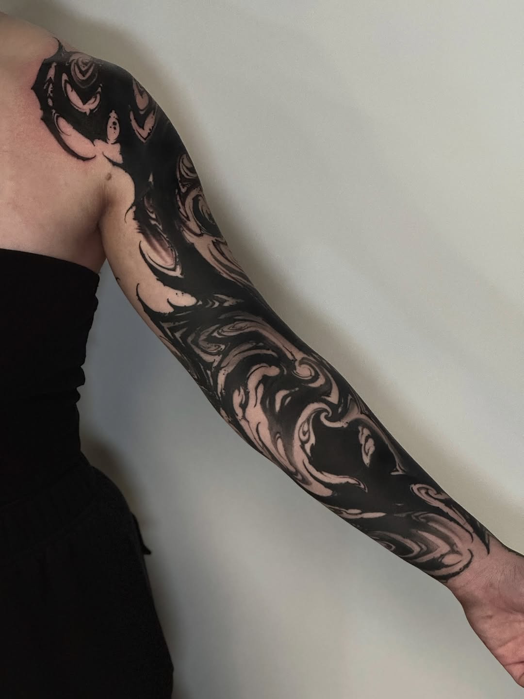 Abstract black ink sleeve blackwork tattoo on the upper arm by Abraxas Tattoo