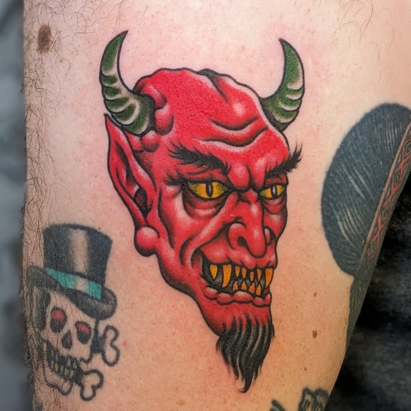 Red devil head American traditional tattoo on the forearm by Matt Simmonds