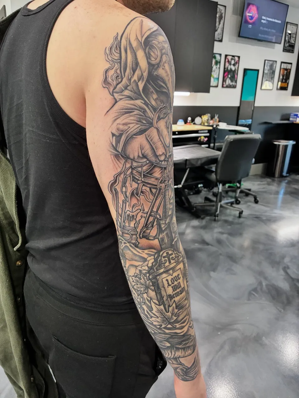 Plague doctor black and grey tattoo on the upper arm by Adam Silfies
