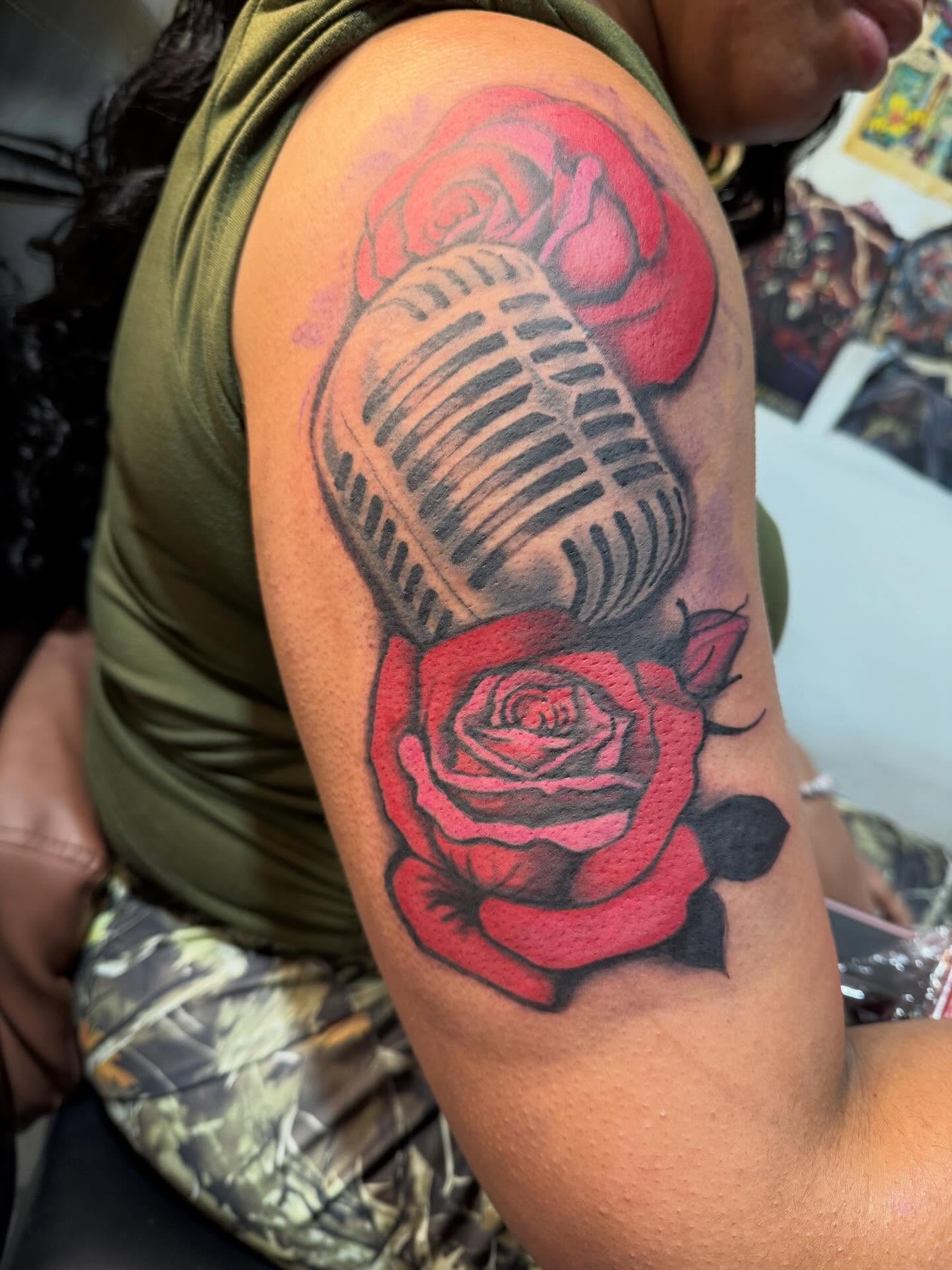 Microphone and roses realism tattoo on the upper arm by Jones Eric