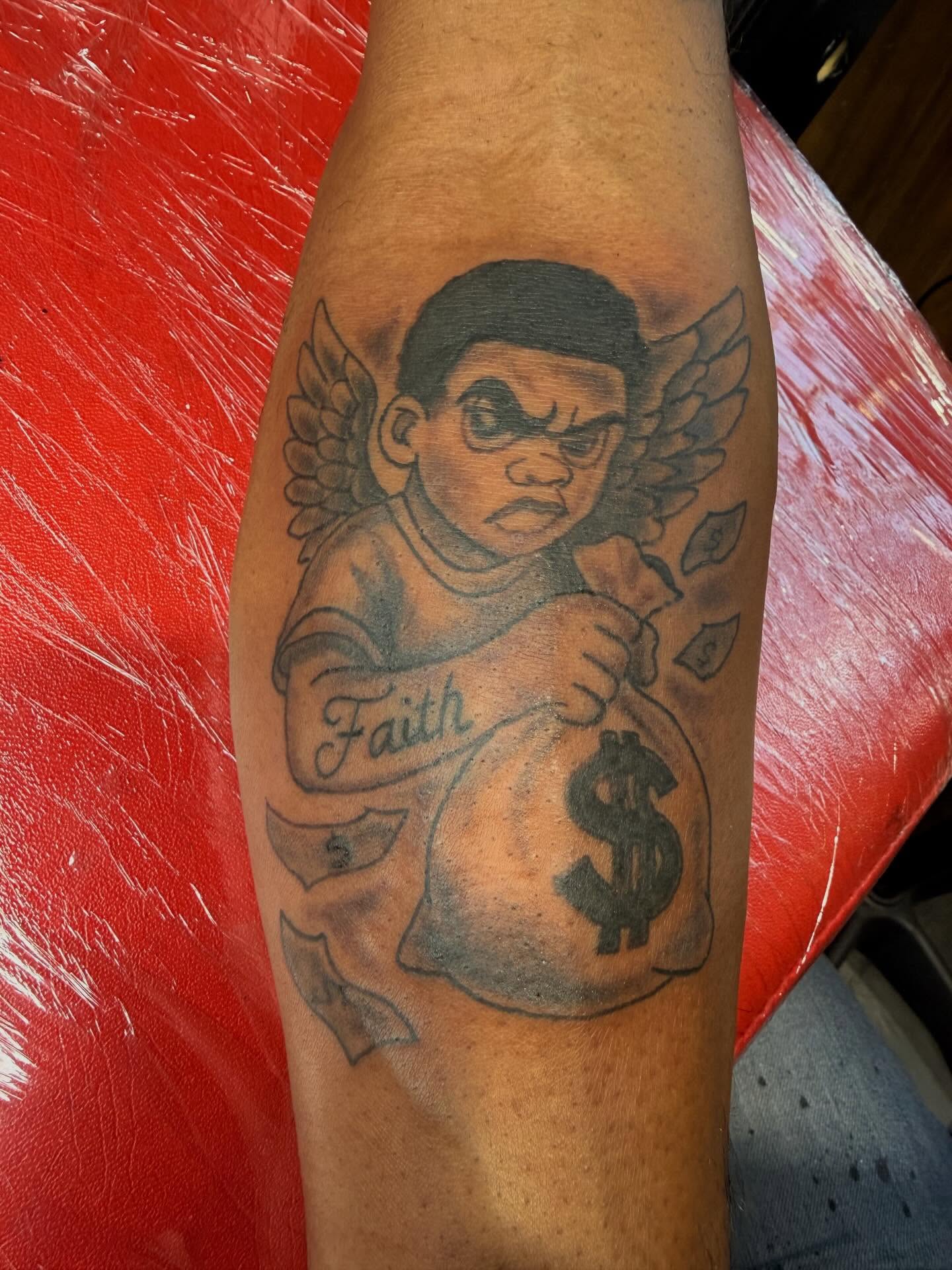 Angel with money bag American traditional tattoo on the forearm by Jones Eric
