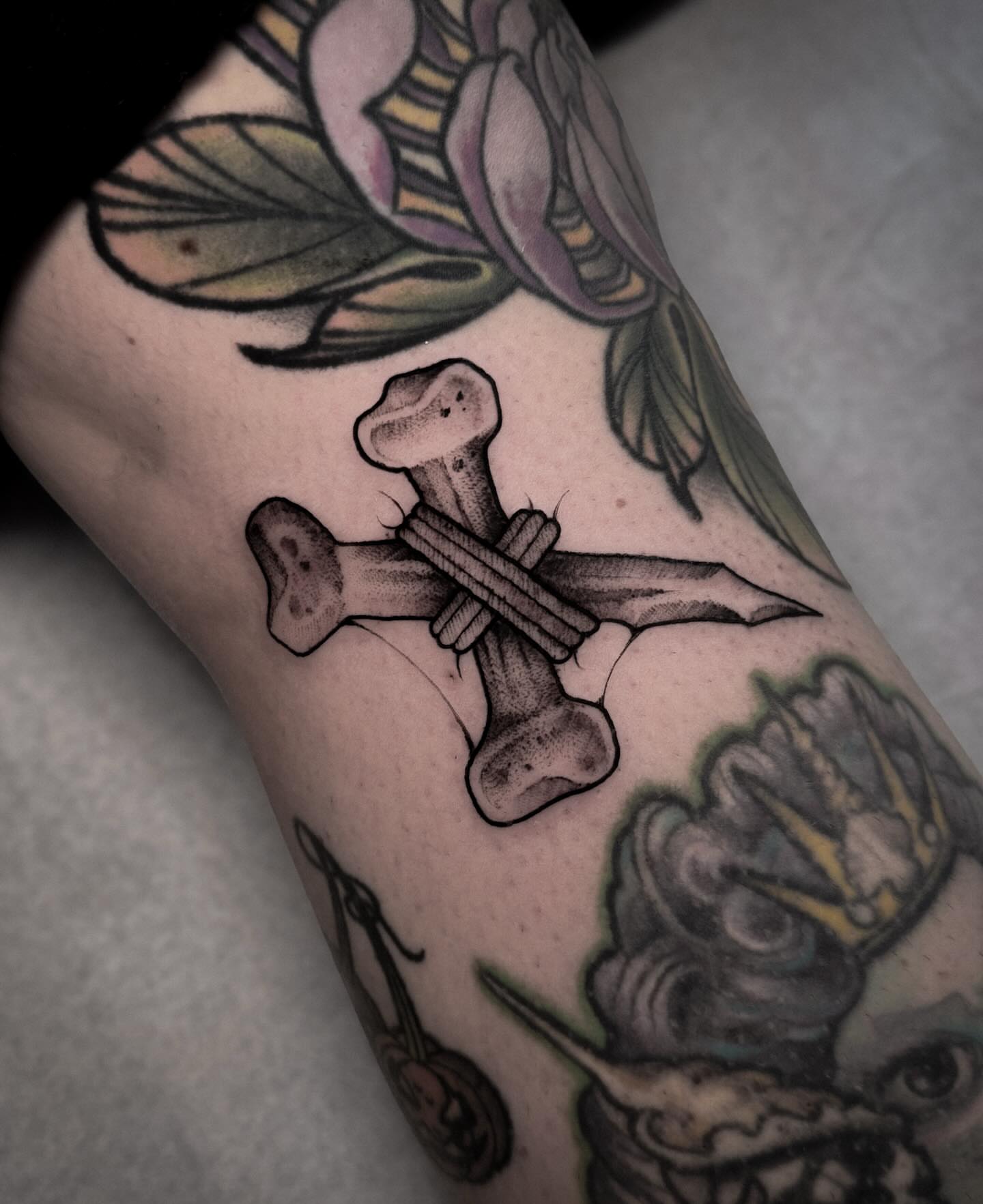 Crossbones black and grey tattoo on the forearm by La Hyene