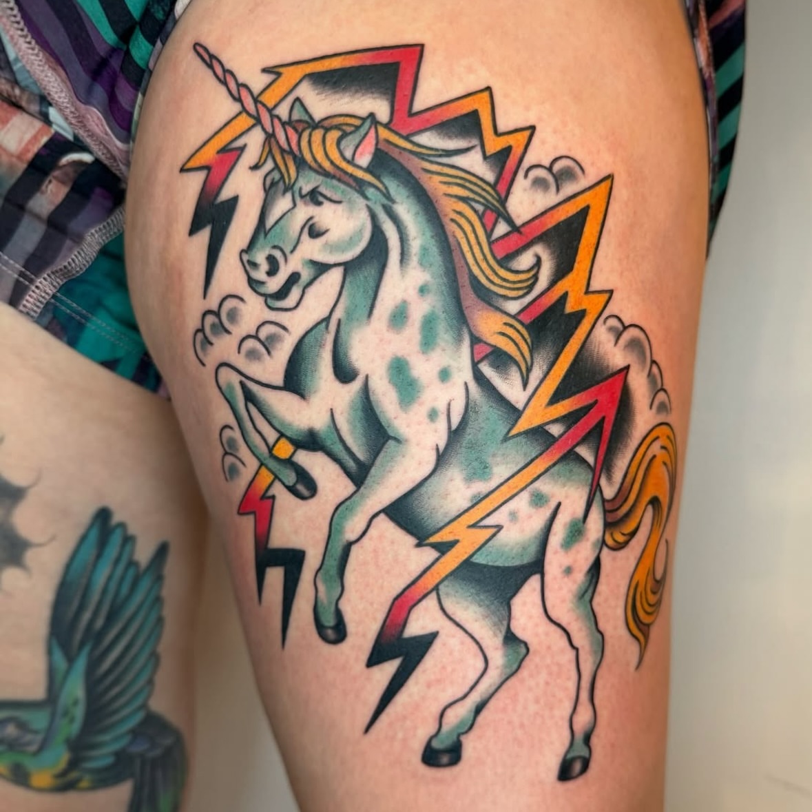 Unicorns and lightning American traditional tattoo on the thigh by Cori James Tattoo Artist