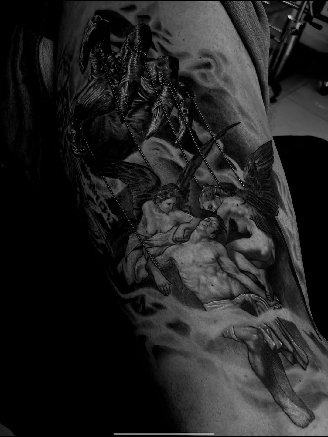 Demon and angels with a man realism tattoo on the upper arm by Tattoo Artist