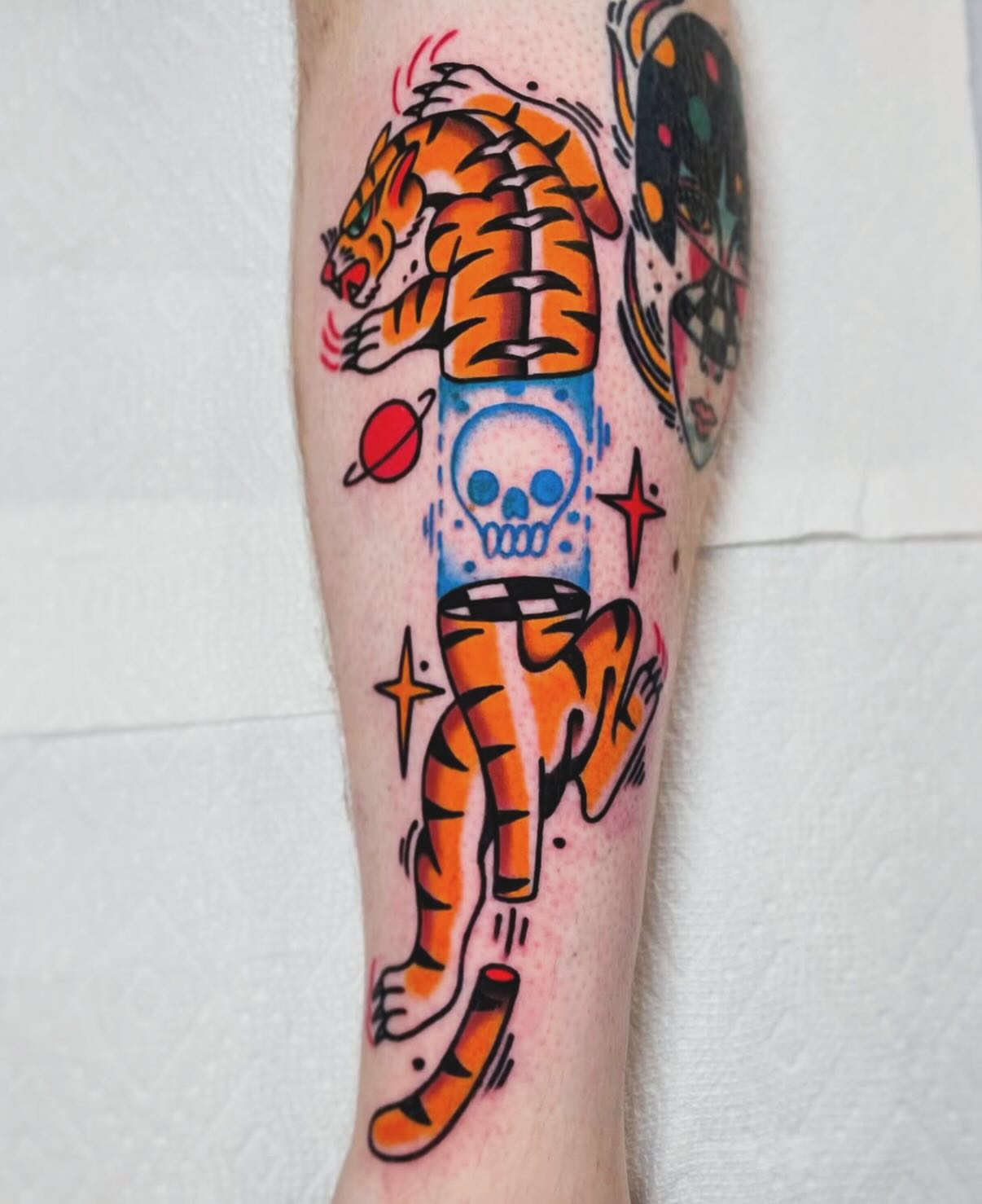 Tiger and skull American traditional tattoo on the calf by Jacob, Marion, Illinois