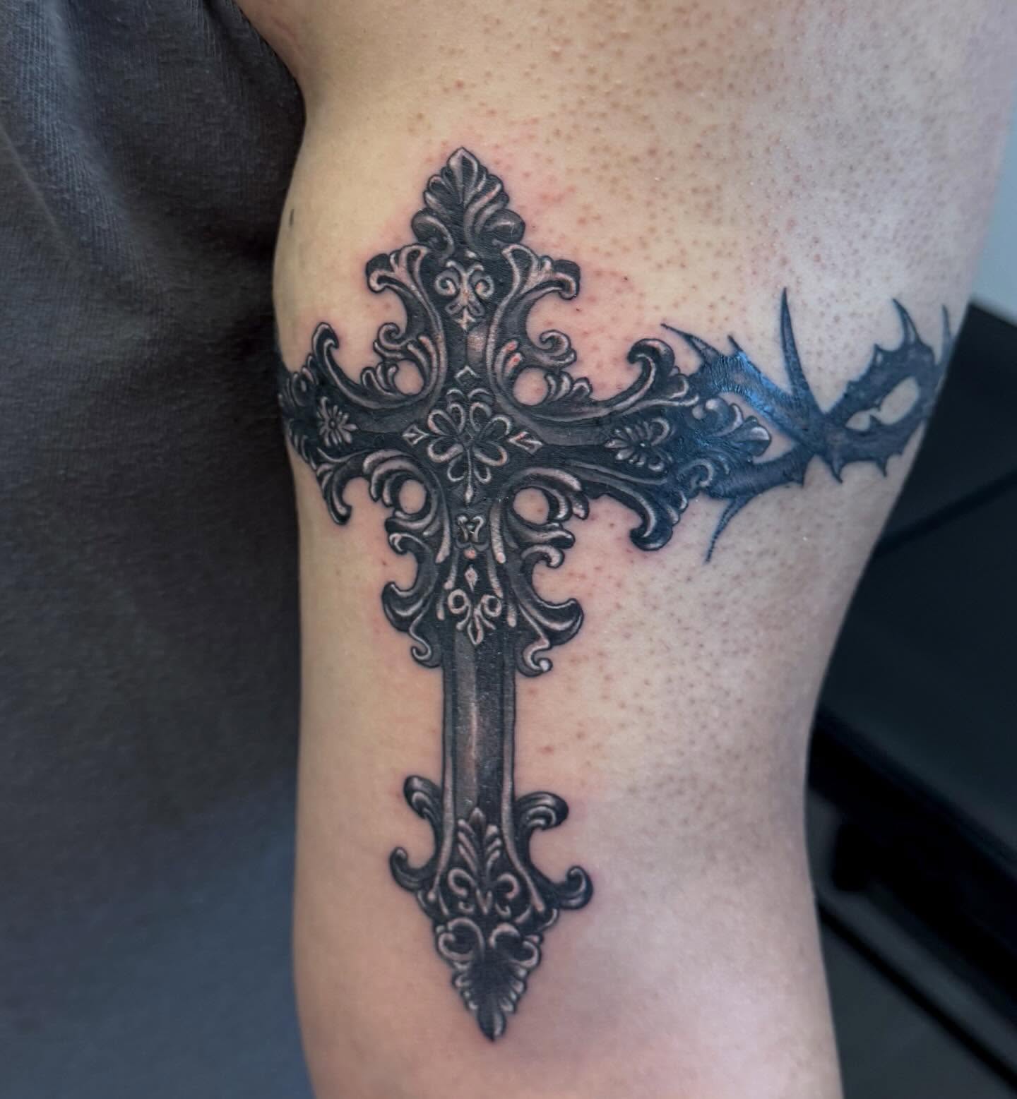 Cross ornamental tattoo on the forearm by Gigi
