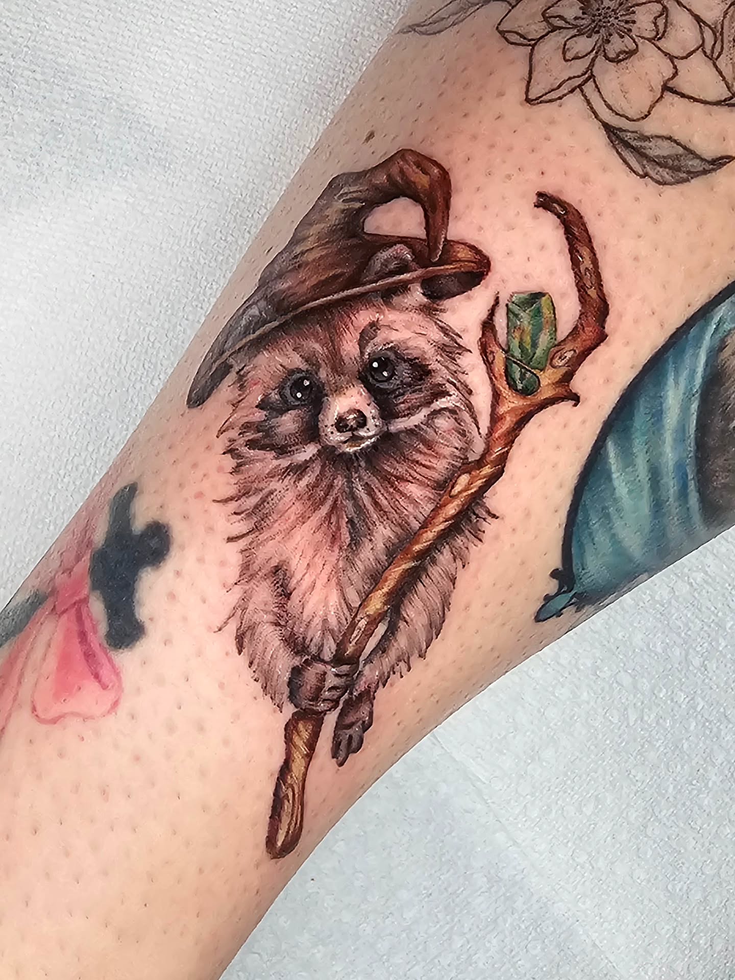 Dog with wizard hat realism tattoo on the forearm by Madelynne