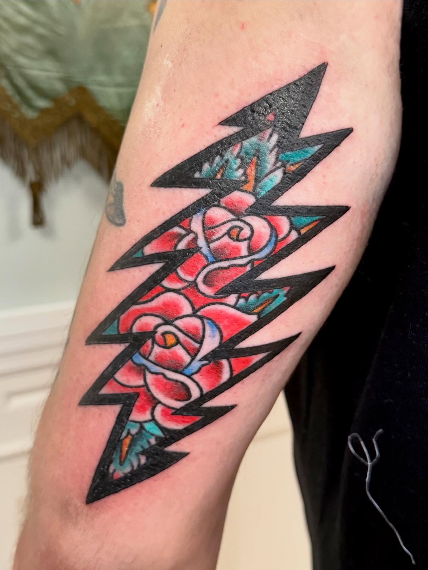 Lightning bolt with roses American traditional tattoo on the forearm by Jesse Boss, Nashville, Tennessee