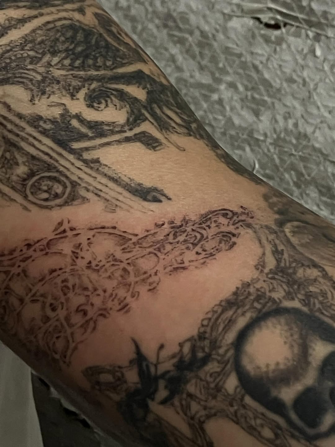Abstract patterns and skull realism tattoo on the forearm by Sashka