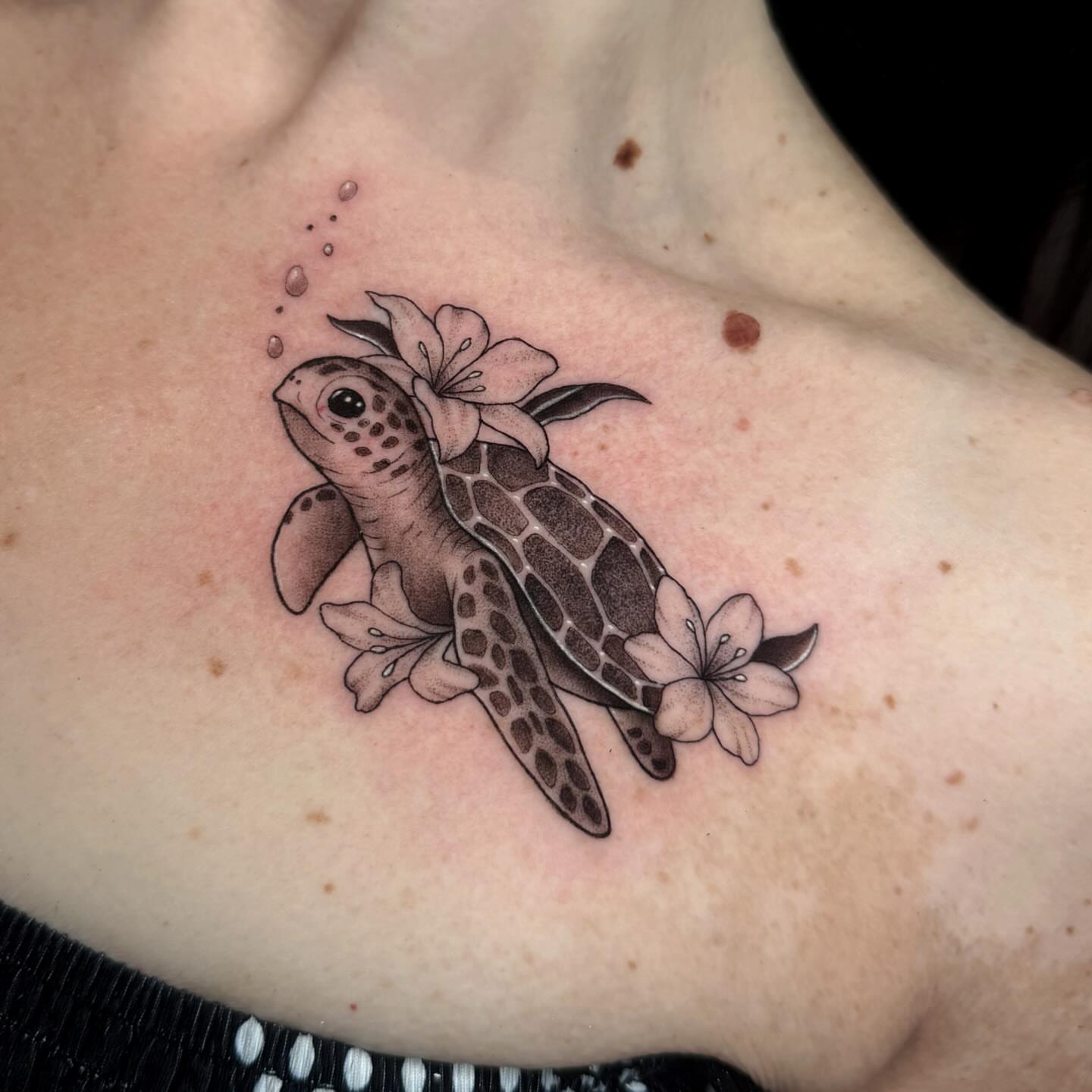 Sea turtle with flowers dotwork tattoo on the chest by Alexia