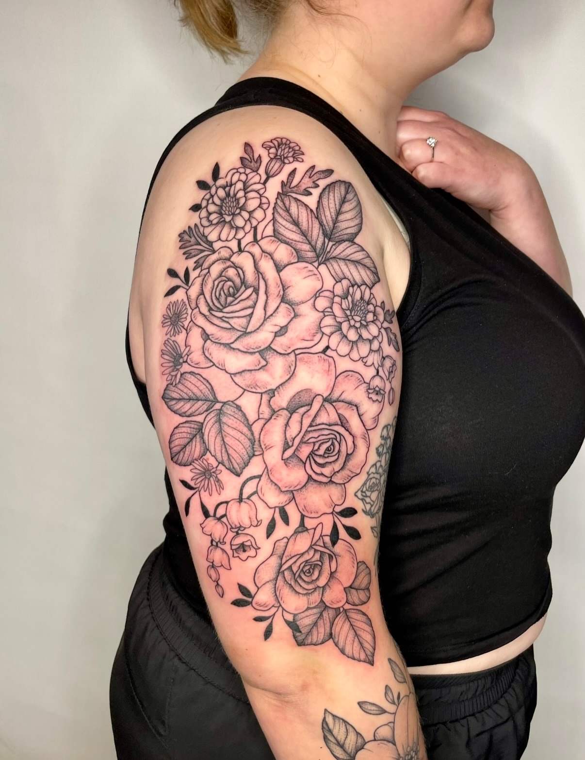 Floral bouquet black and grey tattoo on the upper arm by Hannah, Portland, Oregon