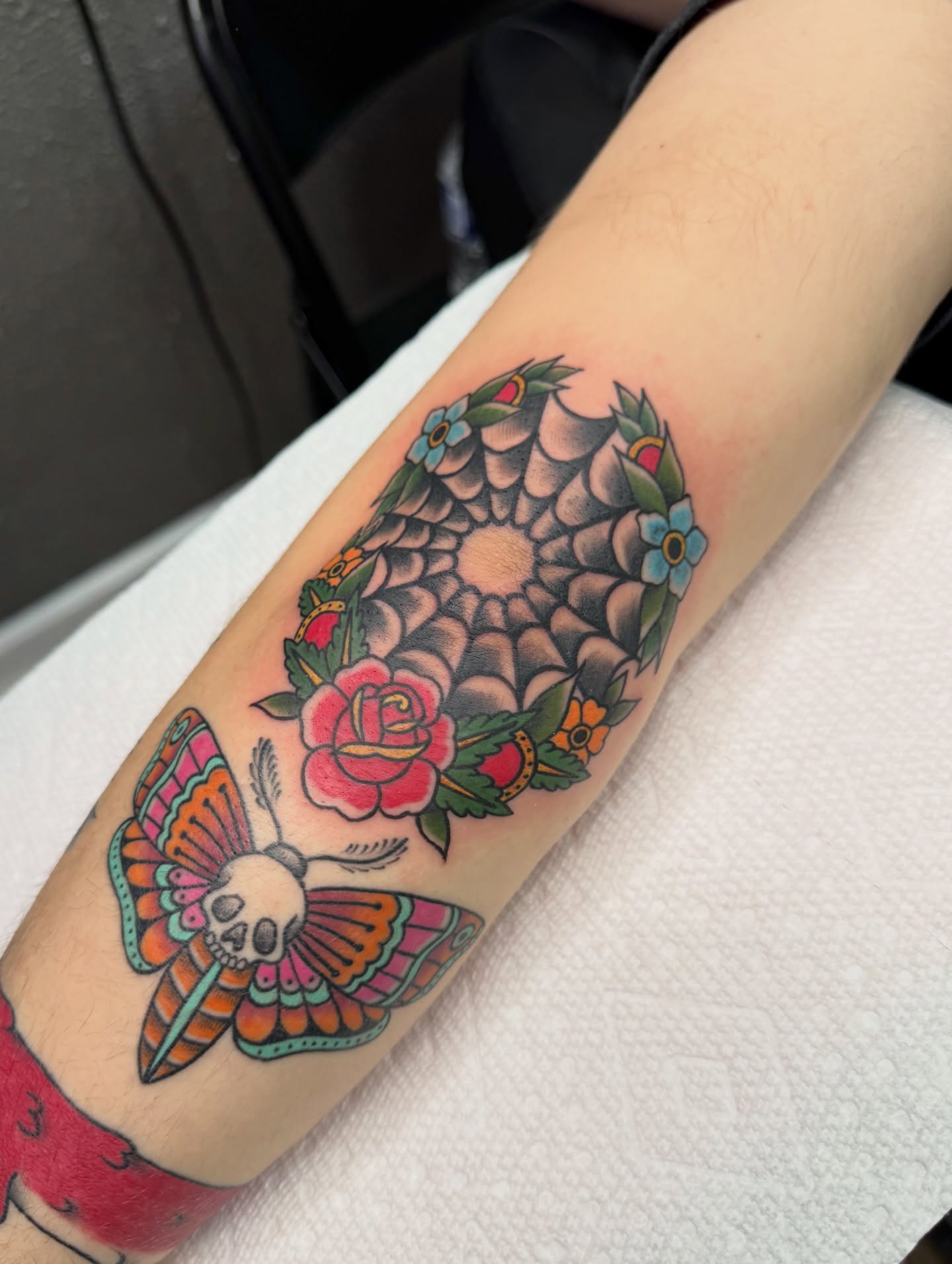 Butterfly skull American traditional tattoo on the forearm by Cora Phelps