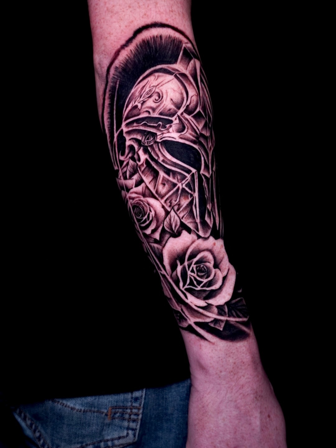 Helmeted warrior with roses realism tattoo on the forearm by Greg Petrali