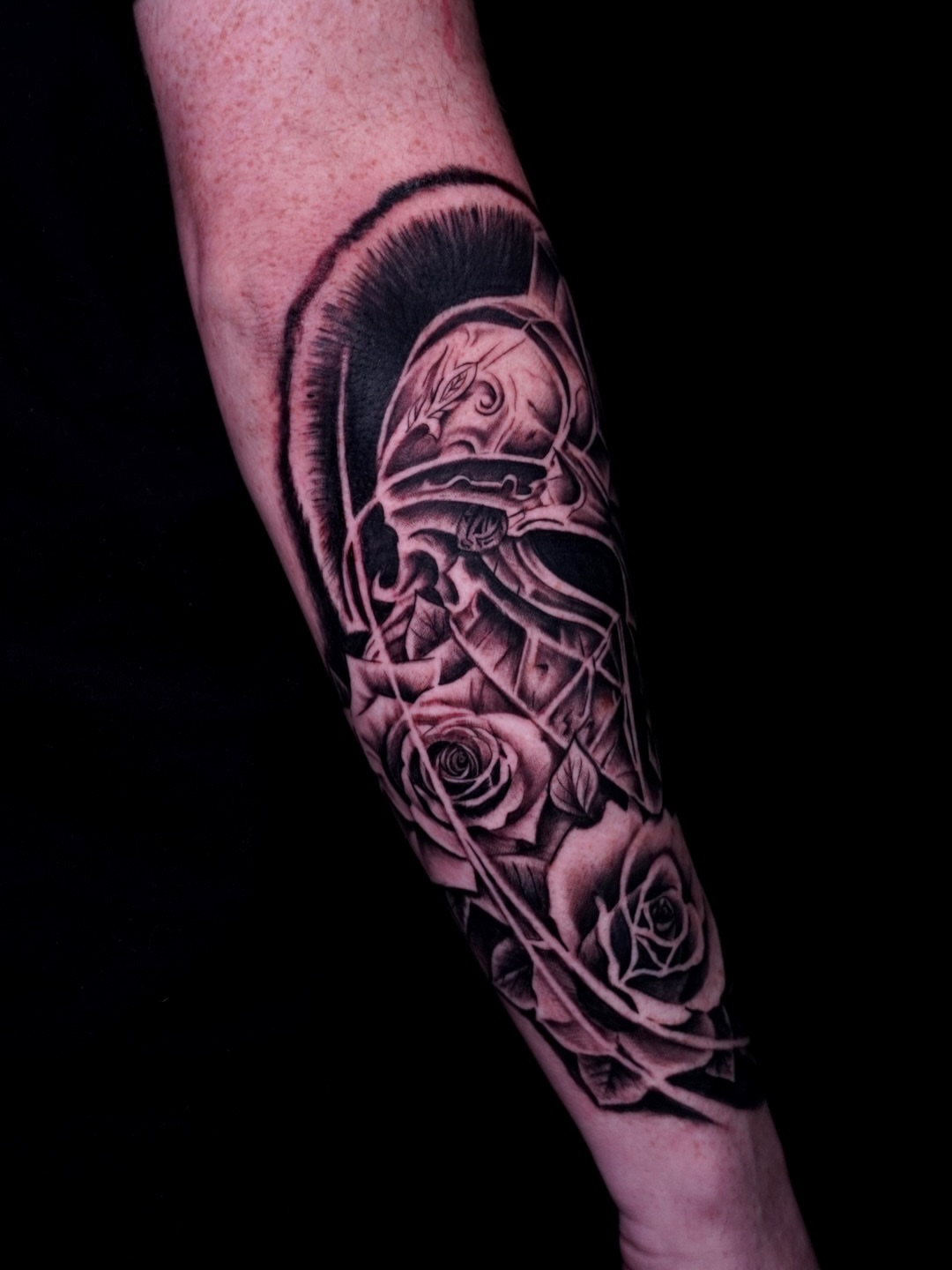Helmet and roses realism tattoo on the forearm by Greg Petrali