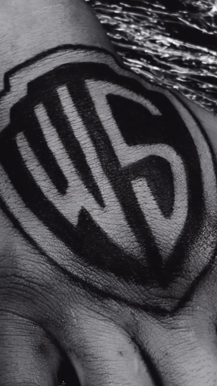 Warner Bros logo on hand tattoo on the hand by Come Get Blasted By Chula💥