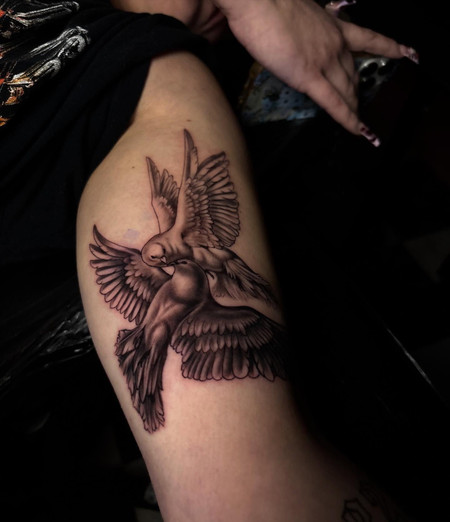 Birds black and grey tattoo on the upper arm by Nikko