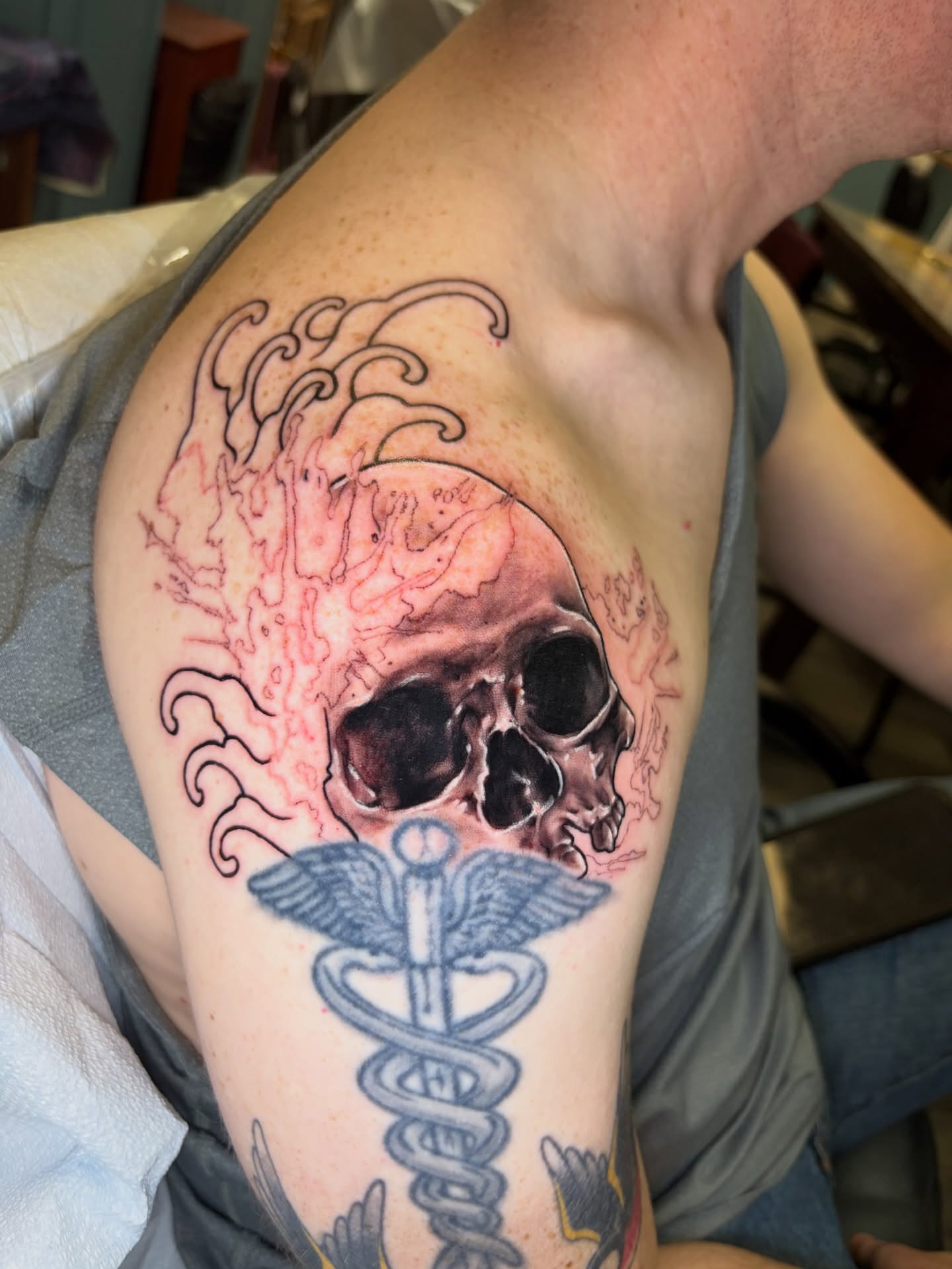 Skull and caduceus American traditional tattoo on the upper arm by Ali Stanley, Virginia Beach, Virginia