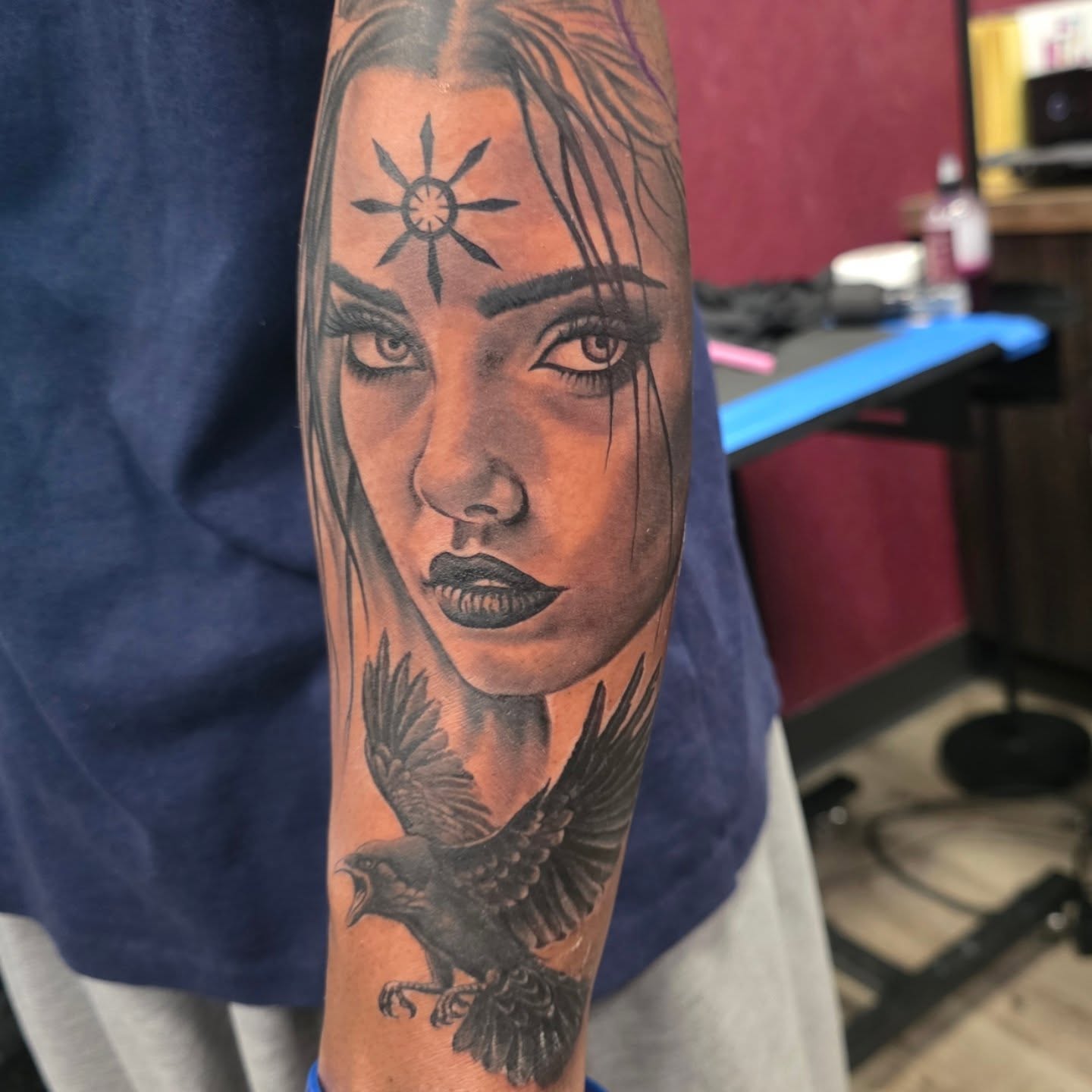 Woman's face with crow realism tattoo on the forearm by Martin Colonna
