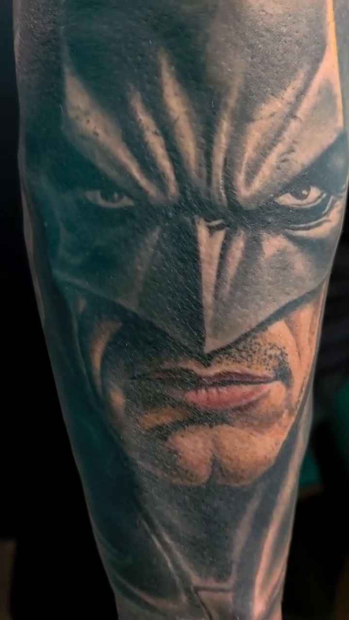 Batman's face realism tattoo on the upper arm by Martin Colonna