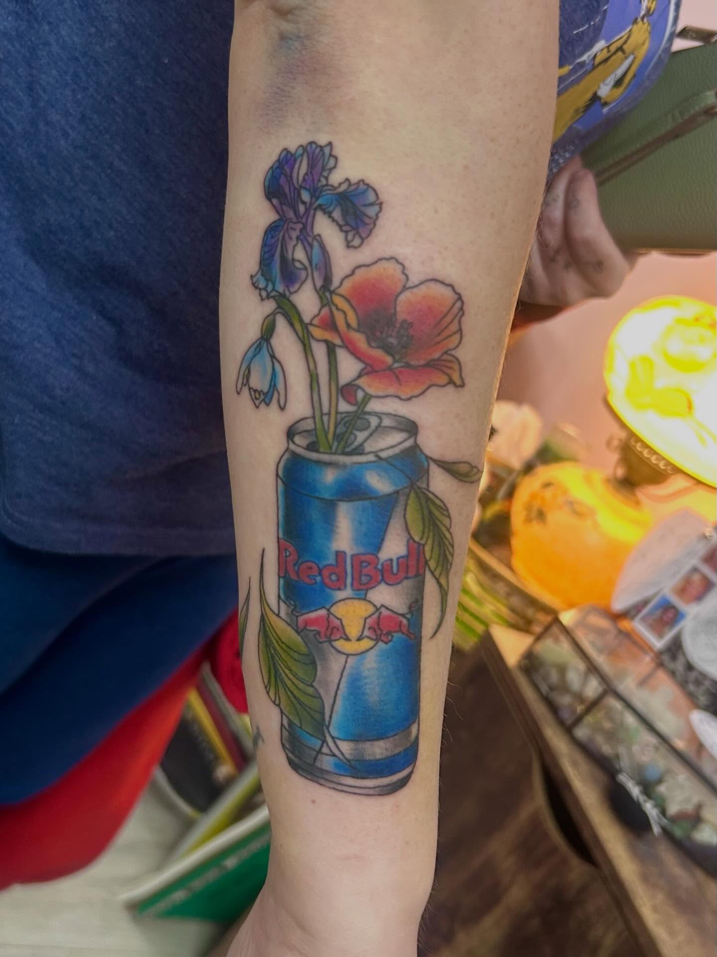 Red Bull can with flowers realism tattoo on the forearm by Red✨, Gansevoort, New York